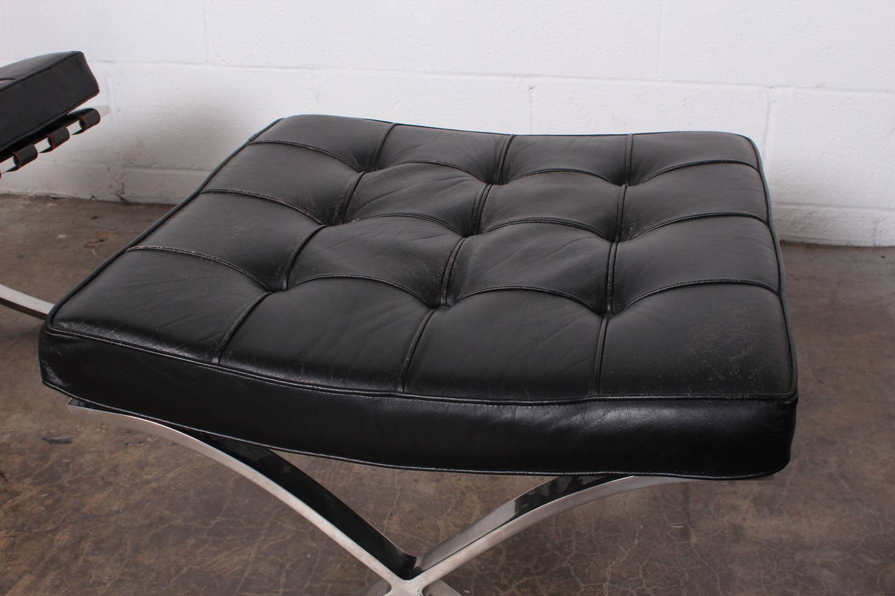 A pair of black leather Barcelona chairs and ottoman with nice patina. Manufactured by Knoll/Art Metal in the 1960s.