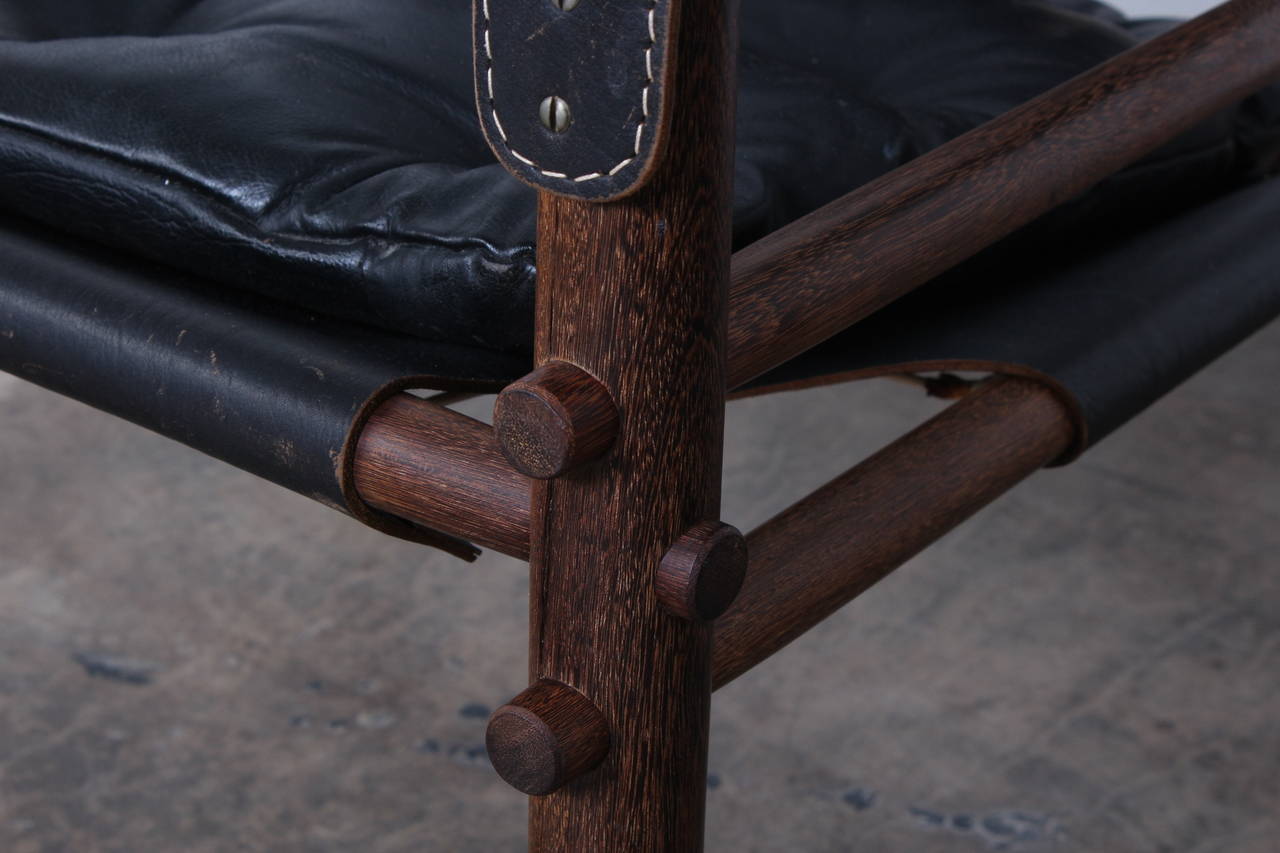 A pair of Sirocco safari chairs in black leather. Designed by Arne Norell.