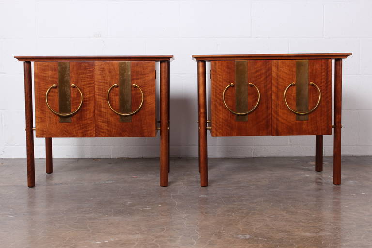 A pair of walnut bedside tables with brass hardware. Designed by Bert England for Johnson Furniture.