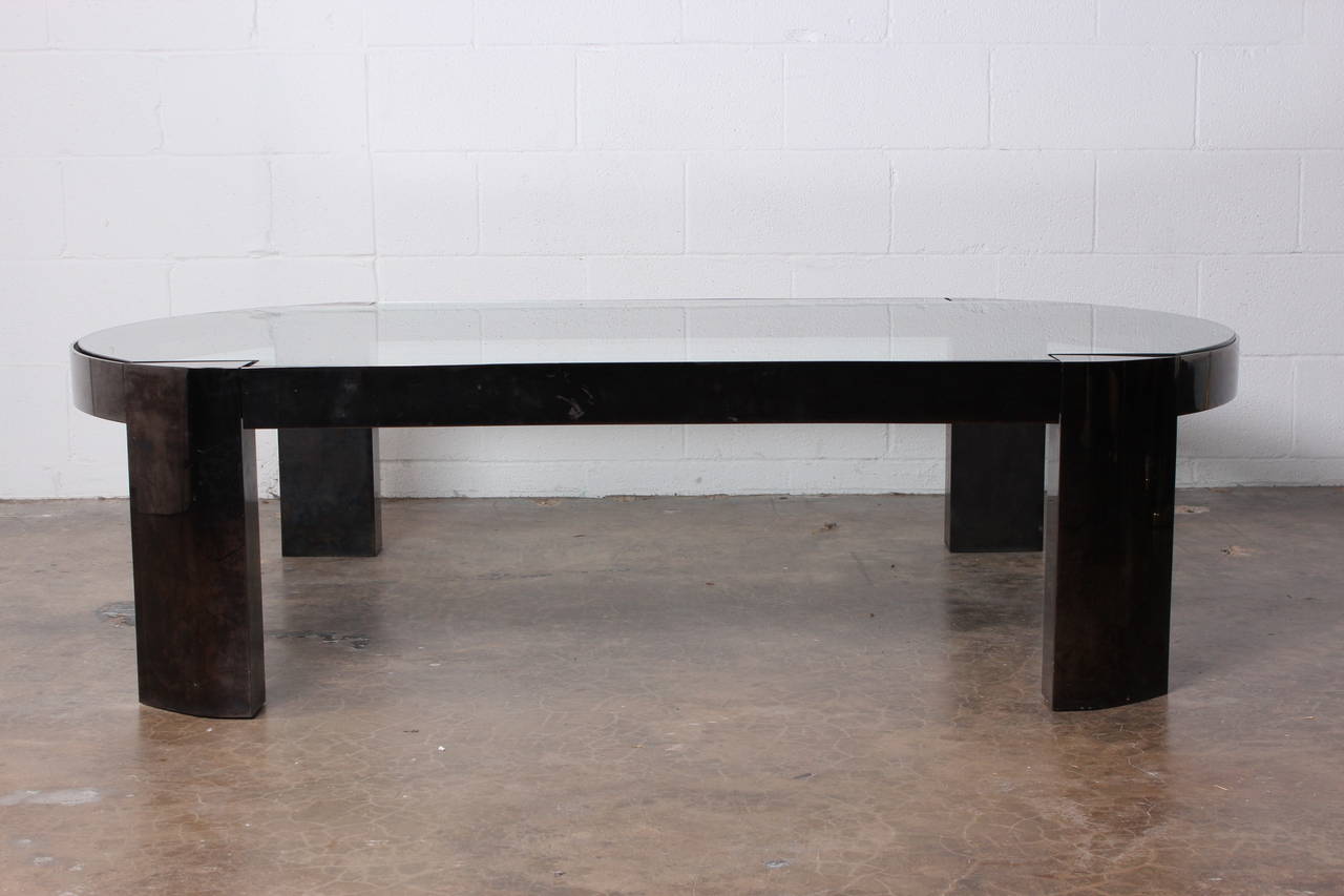 A large coffee table with gunmetal finish and inset glass top. Designed by Karl Springer.