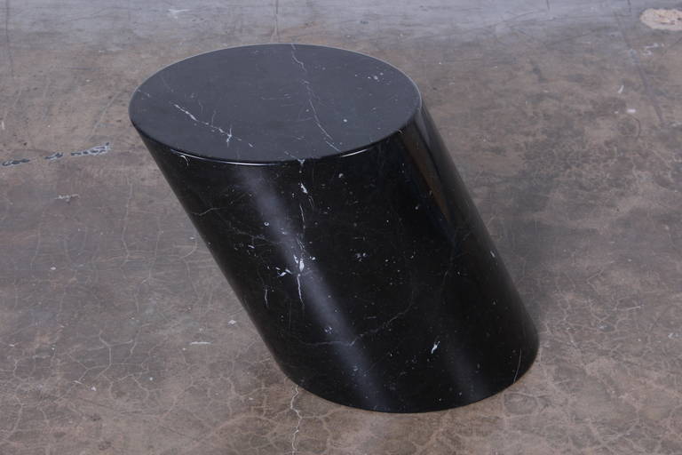 A solid polished black marble side table with white veining. Designed by Lucia Mercer for Knoll.