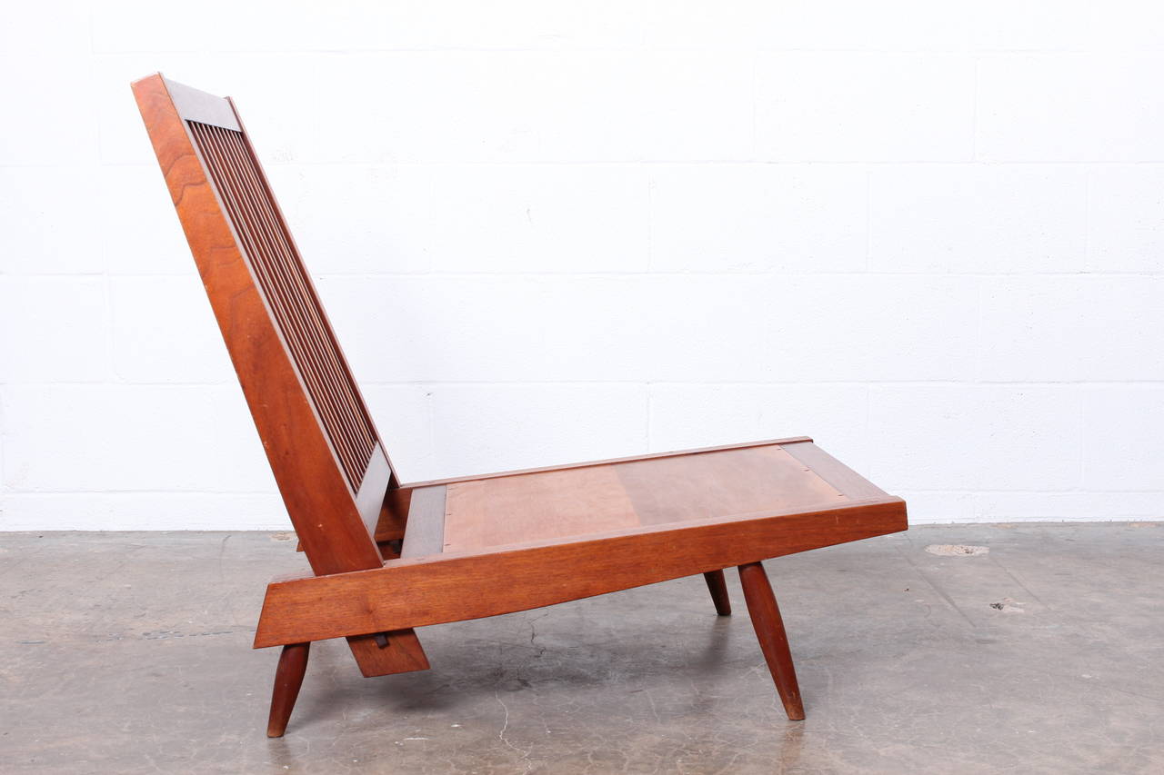 A walnut spindle back lounge chair by George Nakashima. Sold with copy of original invoice. Matching settee also available.
