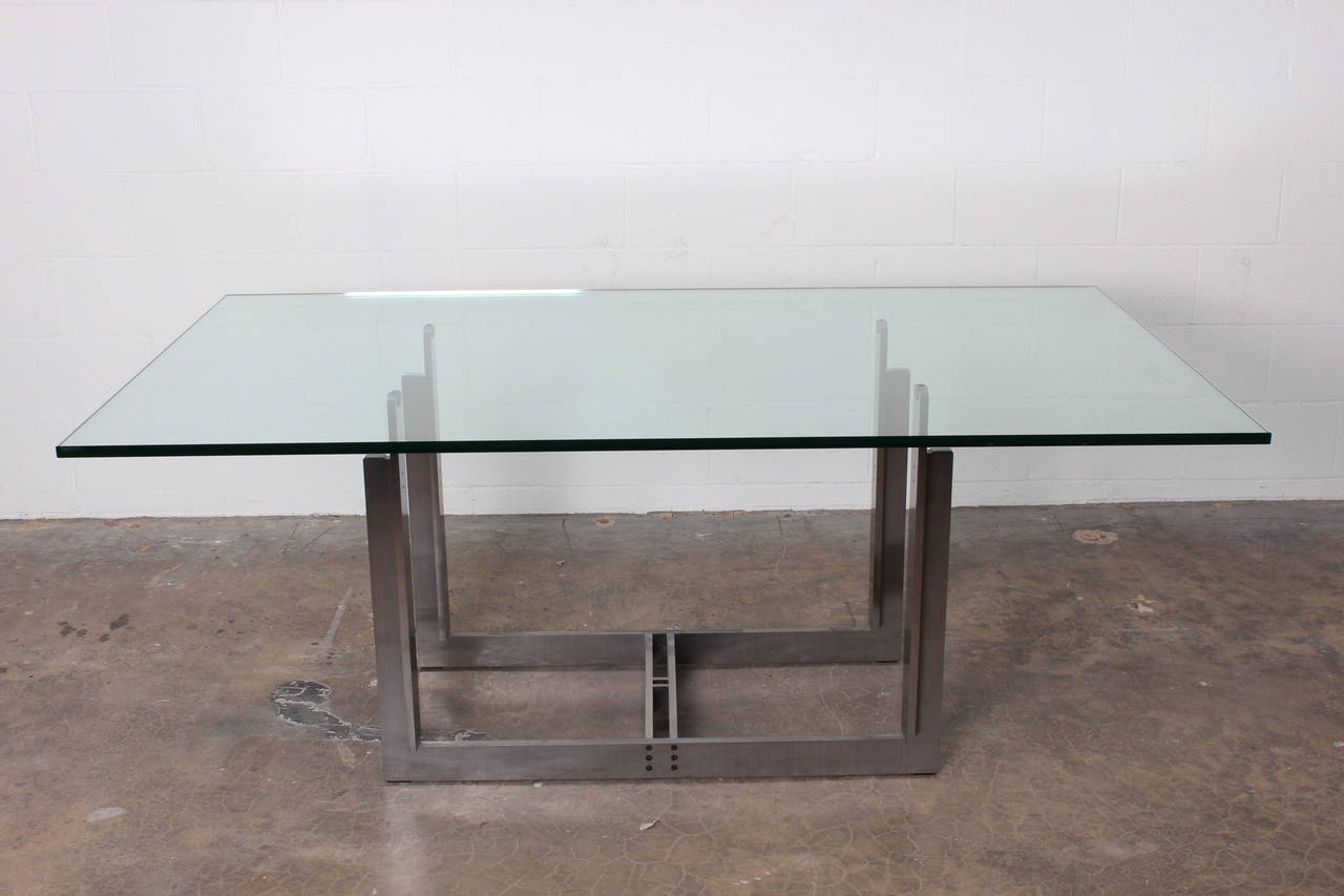 A dining table or desk designed by Carlo Scarpa with solid stainless steel base, brass fittings and glass top.