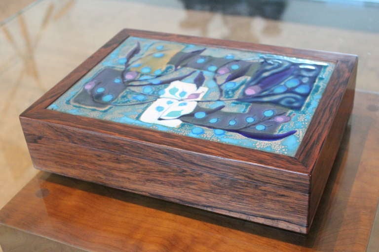 A fine rosewood and enamel on copper cigar box by Maria Viktor and Alfred Klitgaard.  Superior construction with hidden hinges, movable inner spacers, lighter and cutter.