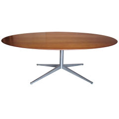 Walnut elliptical dining table by Florence Knoll