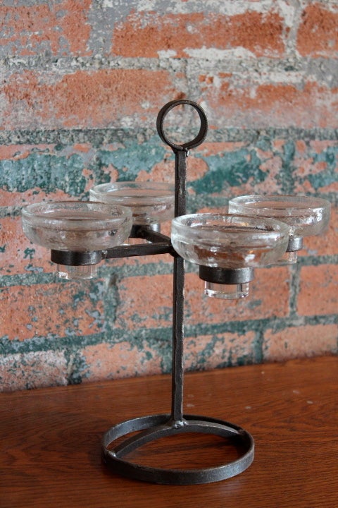 A simple iron and glass table top candelabra designed by Erik Hoglund. The candle holders can use three different size candles.