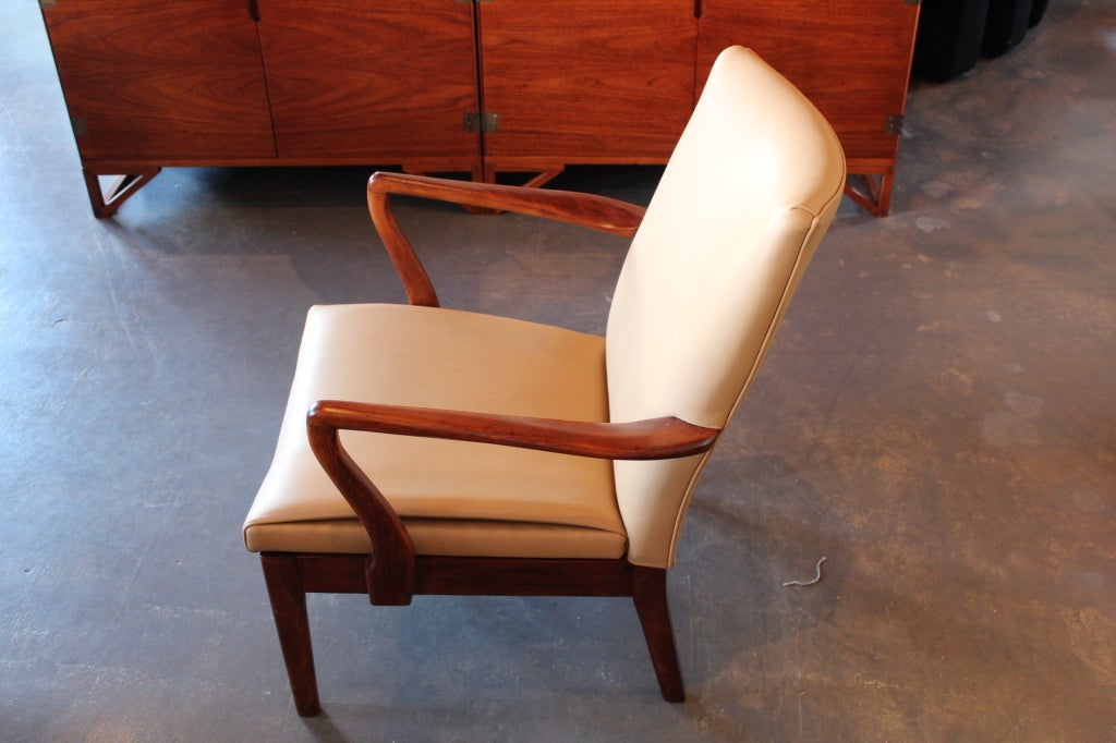 A pair of walnut and leather lounge chairs by Parker knoll.