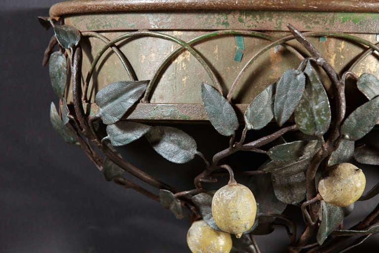 A forged iron and painted tole demi-lune shaped wall pocket with leaf and lemon decoration. Condition is fine. Appears to be all original. Mid- 20th century.