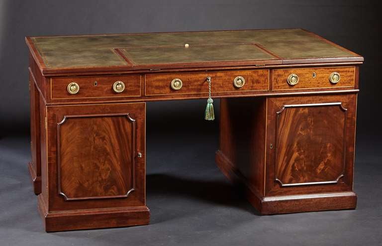 A classical proportioned and finely executed Georgian mahogany pedestal partners desk. The new leather top with gilt tooling and mechanical writing slope both crossbanded in rosewood and above a three drawer case top raised on three pedestals with