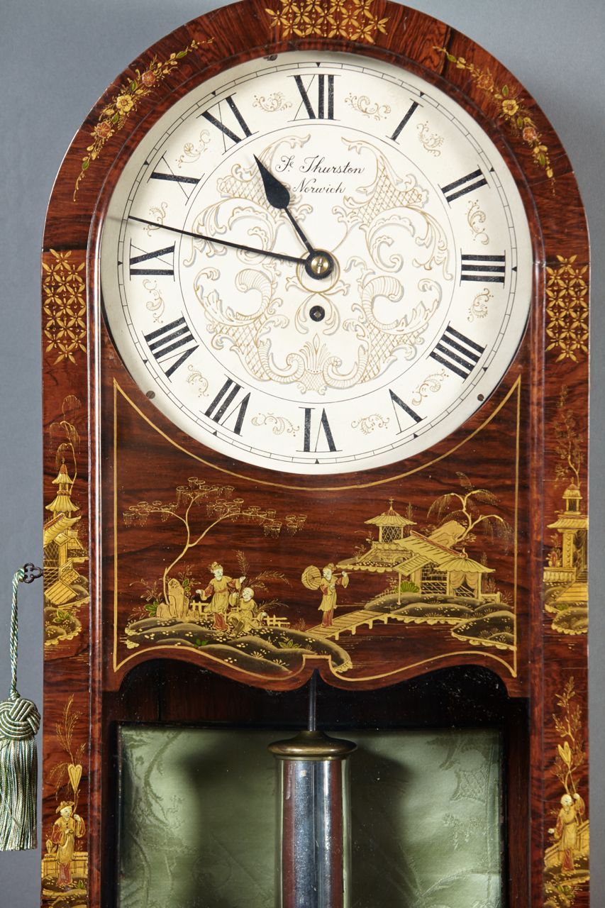 An English regency period rosewood hanging wall clock having original Chinoiserie painted decoration and painted dial signed F. Thurston, Norwich. The case with pastoral scenes with figures withing landscapes, a glass door and incorporated drop