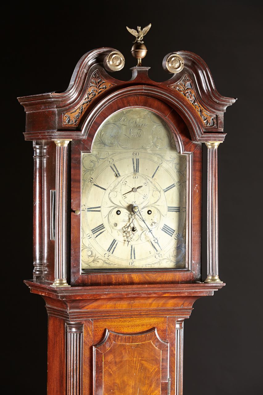 A Scottish mahogany tall clock by David Norrie of Leith, Scotland having a broken arch pediment above a signed and engraved bronze arched dial. The case with inlays and fine graining above a bracket footed base. Leith, Scotland, circa 1800.  Fine