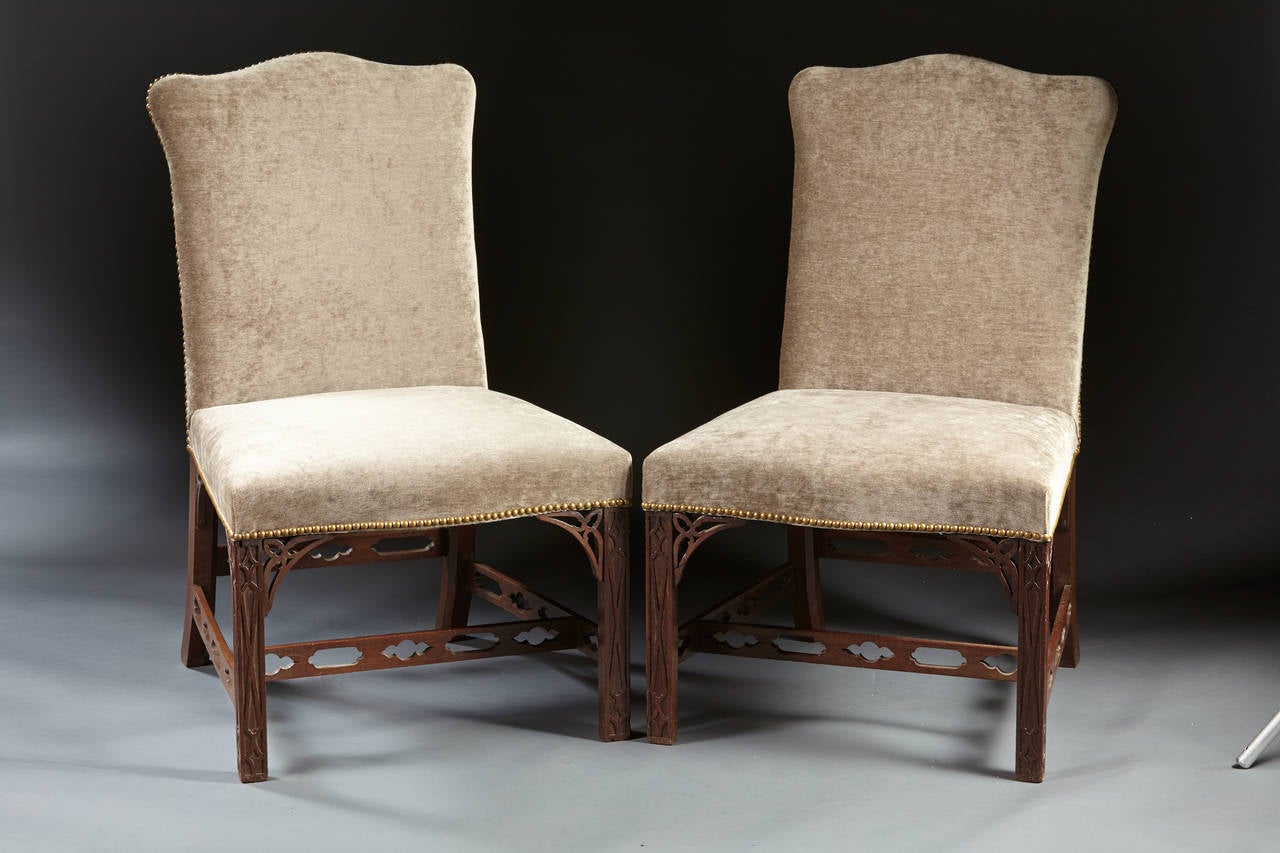 A very fine set of six fretwork Chippendale backstools with upholstered, shaped backs on serpentine shaped seats supported on blind fret mahogany Marlborough legs with open fret carved “H” stretchers. English, circa 1760. Frames and fretwork all