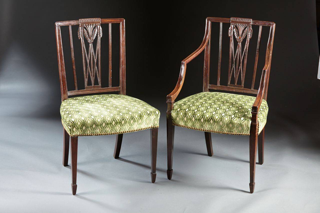 A very fine set of eight chairs of the Hepplewhite period with carved wreath crests and lattice work backs above over-upholstered seats on tapered legs ending in spade feet. Newly covered in contemporary fabric. In the manner of Gillows and