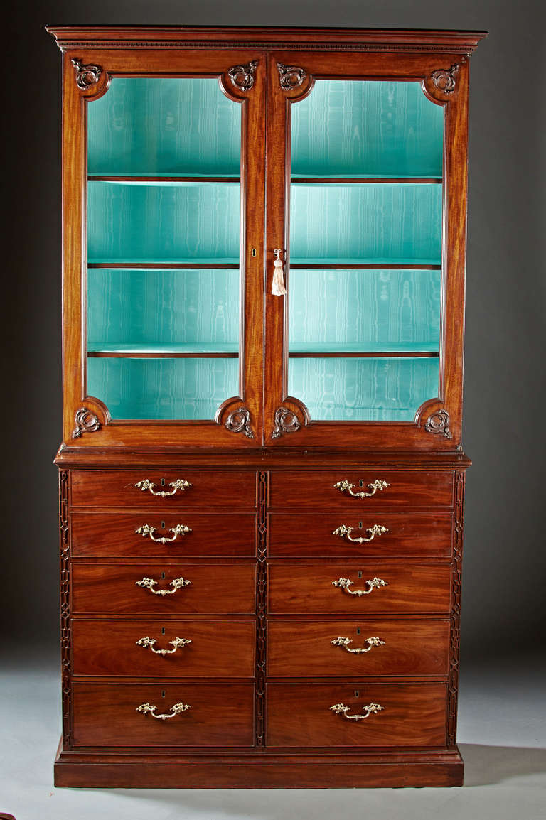 An impressive mahogany Gillows secretary bookcase with dentil crown molding over glazed doors with carved appliqué corners and adjustable shelved interior on a secretaire base with butler's pull out desk. The fitted desk interior with pigeon holes
