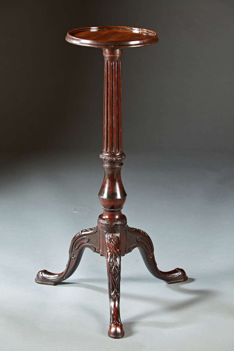 A George II tripod table with a dish top, carved column shaft on tripod base with carved strap work legs ending in slipper feet. This table retains a mellow rich patina and has a delicate beauty to it. English, circa 1750  Ex. coll. Stair and Co.