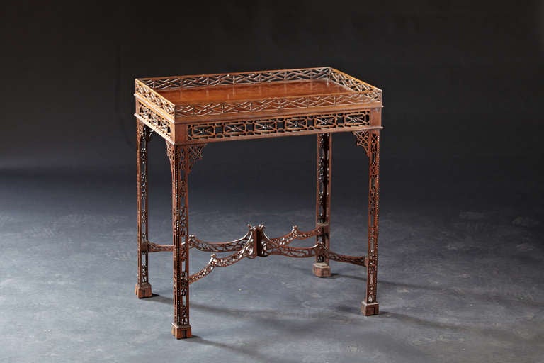 A diminutive mahogany fretwork teat table. The pierced fretwork gallery with thin molded top is supported by four carved and pierced fretwork legs ending in guttae feet and joined together by an arched pierce fretted cross stretcher. (Partial repair