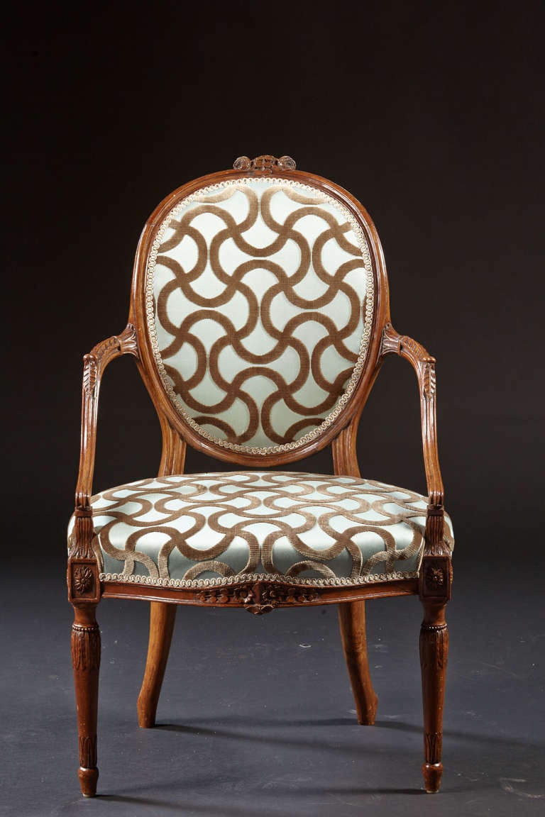 A George III Hepplewhite ovalback carved fauteuil with downswept 