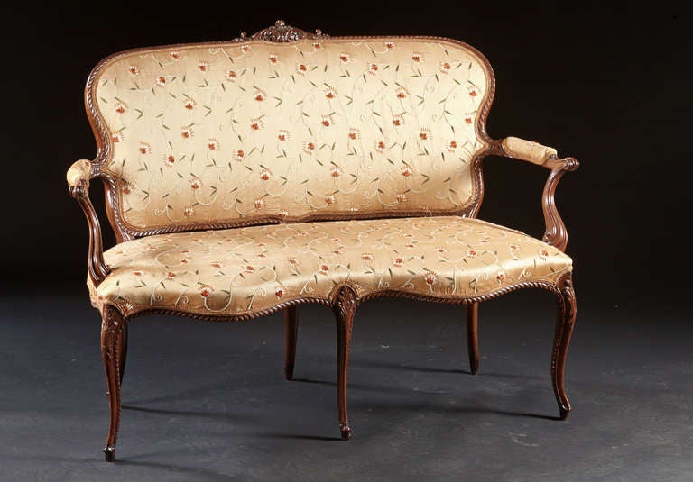 A very delicate cabriole leg settee with mahogany carved frame. The crest is acanthus carved over an ovoid shaped backrest with gadrooned borders. The serpentine carved arms join the back to a double serpentine shaped seat on acanthus and gadroon