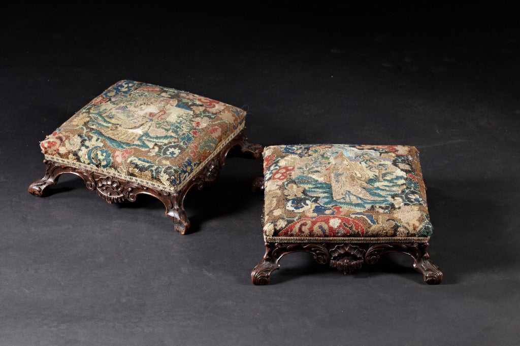 A Pair of Rococo Carved Mahogany Footstools in Needlepoint