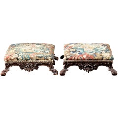A Pair of Rococo Carved Mahogany Footstools in Needlepoint