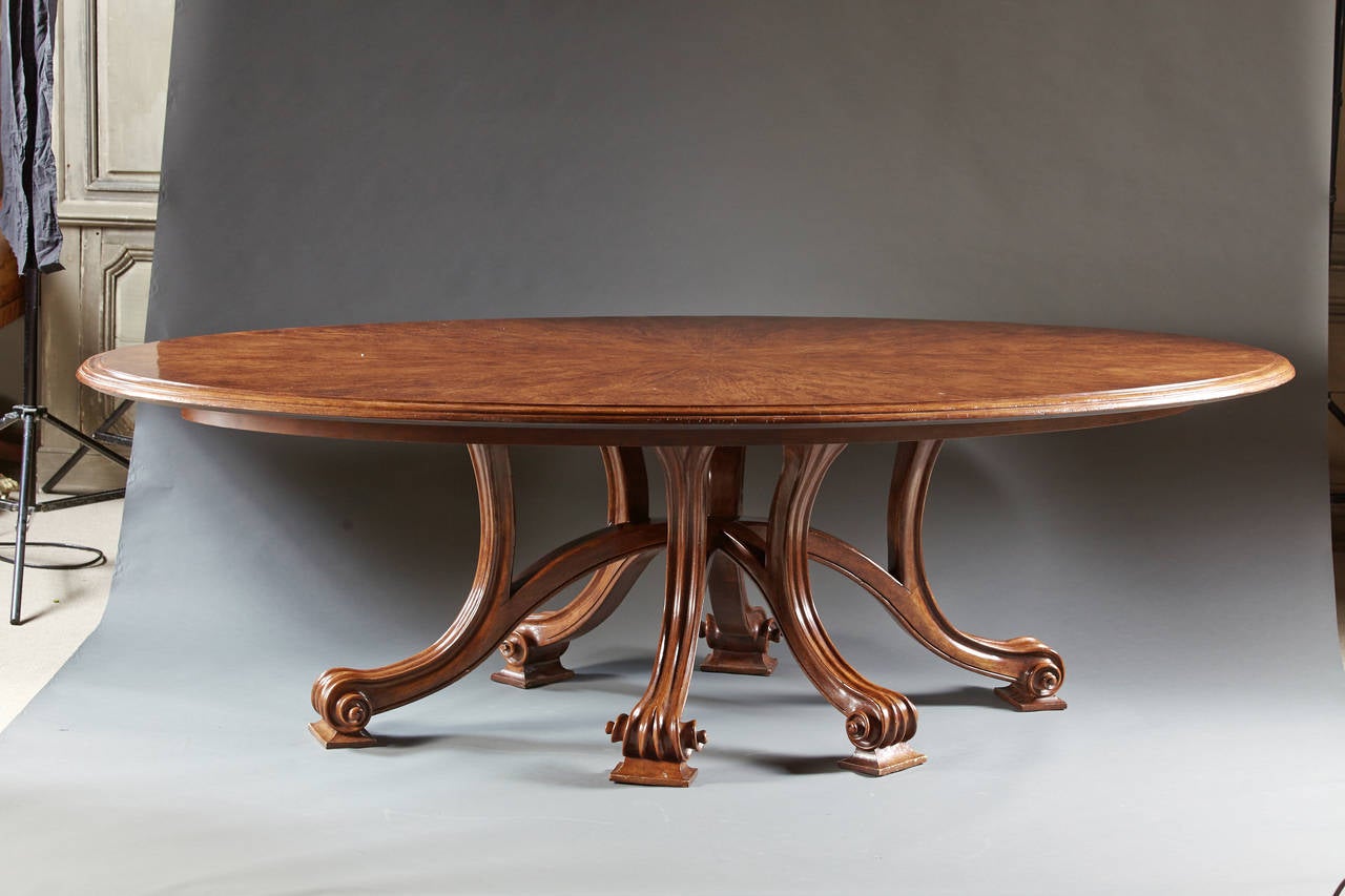 A great large-scaled walnut dining or conference table designed by Robert Couturier. The sunburst patterned top is veneered in walnut on a hardwood and rests on six molded and downswept legs ending in scrolled feet on square bases. A highly