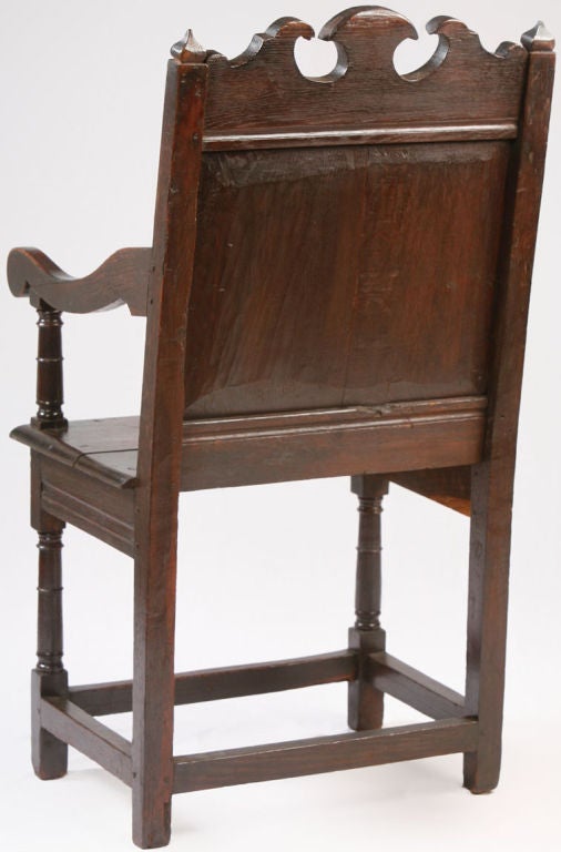 Nice Early Wainscot Armchair with a shaped crest, paneled back,<br />
shaped arms with a plank seat raised on turned legs with stretchers
