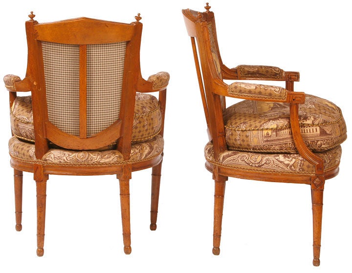 Pair of walnut French Directoire open armchairs of architectural form. Newly upholstered with scenes of Classical buildings.