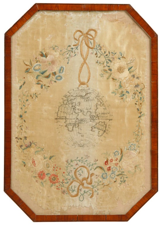 Rare pair of silk  needlework pictures one showing the western hemisphere
the other the eastern hemisphere hanging from ribbons surrounded by vines and flowers in the original tulipwood and satinwood frames