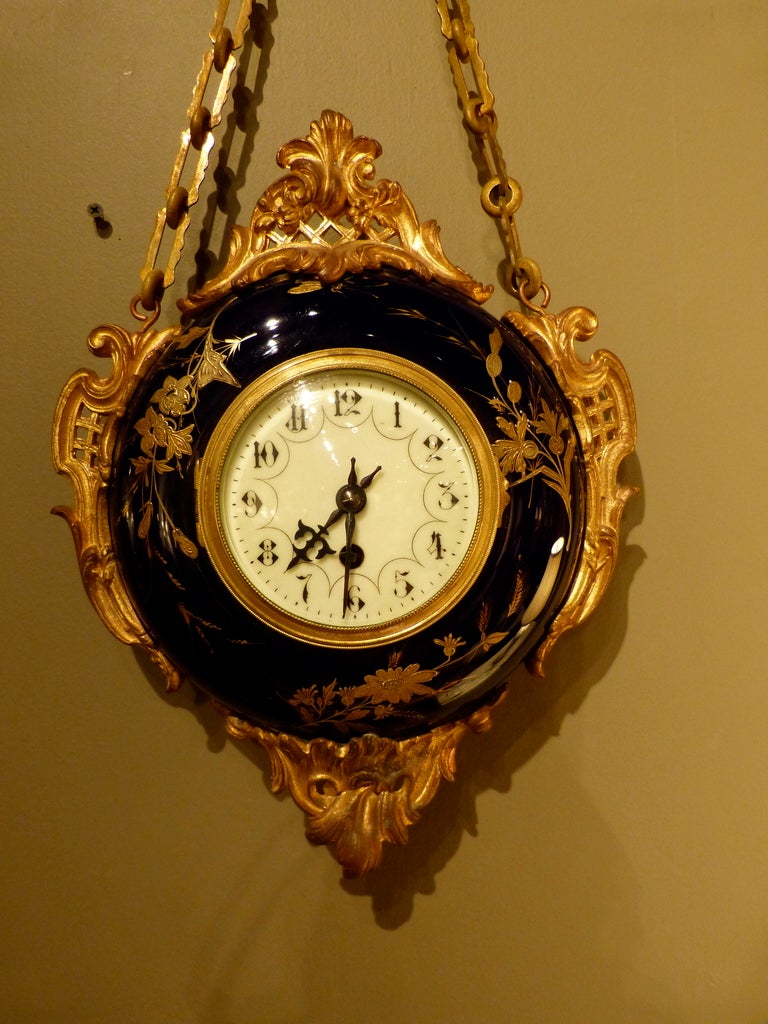 A good French 19th century porcelain and ormolu wall clock with ormolu mounts, enamel face and Roman numerals. The porcelain decorated with gilt floral design, circa 1870.