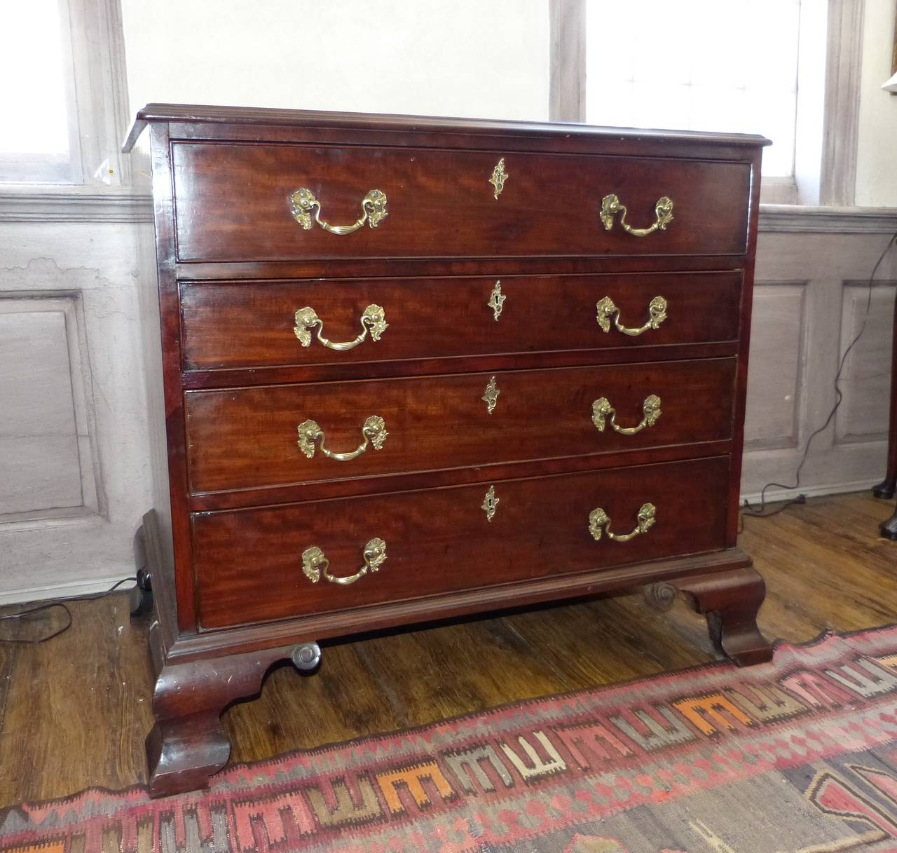 A handsome English 18th century George III Cuban mahogany Chippendale chest with a writing and reading pull-out top drawer on ogee shaped feet, circa 1770.