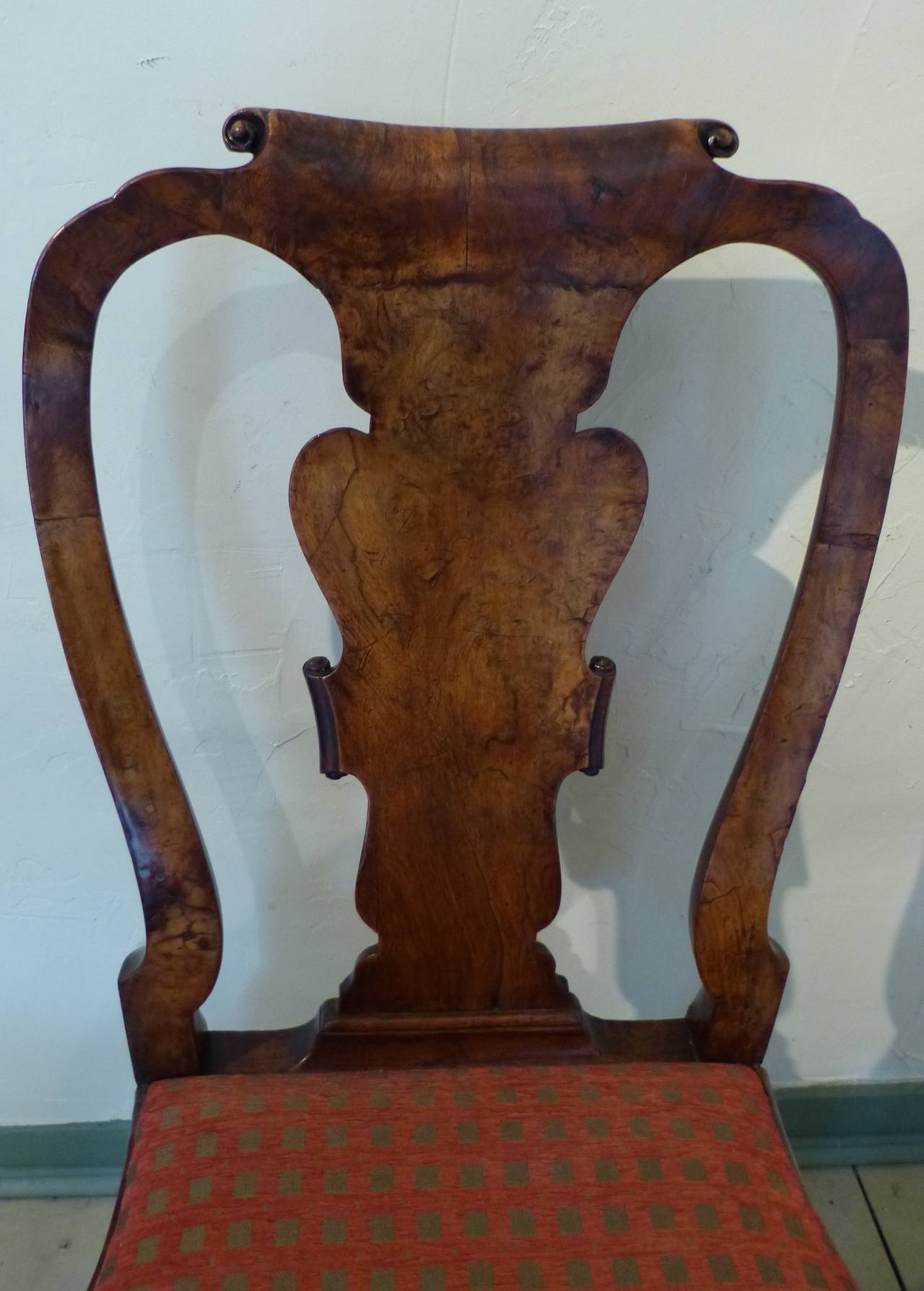 A fine quality English walnut early 18th century chair with shaped cabriole legs topped by carved acanthus leaf at the knees ending in slipper feet. The vasiform back splat with scrolled top and sides and shaped back supports, circa 1740.