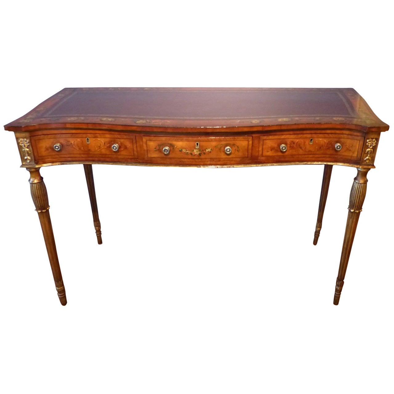 A fine and rare George III satinwood and painted with floral wreaths on gilt and fluted legs surmounted by carved gilt gesso inverted bellflower design. The front of serpentine shape with gilding to the edges of the leather top, circa 1790.