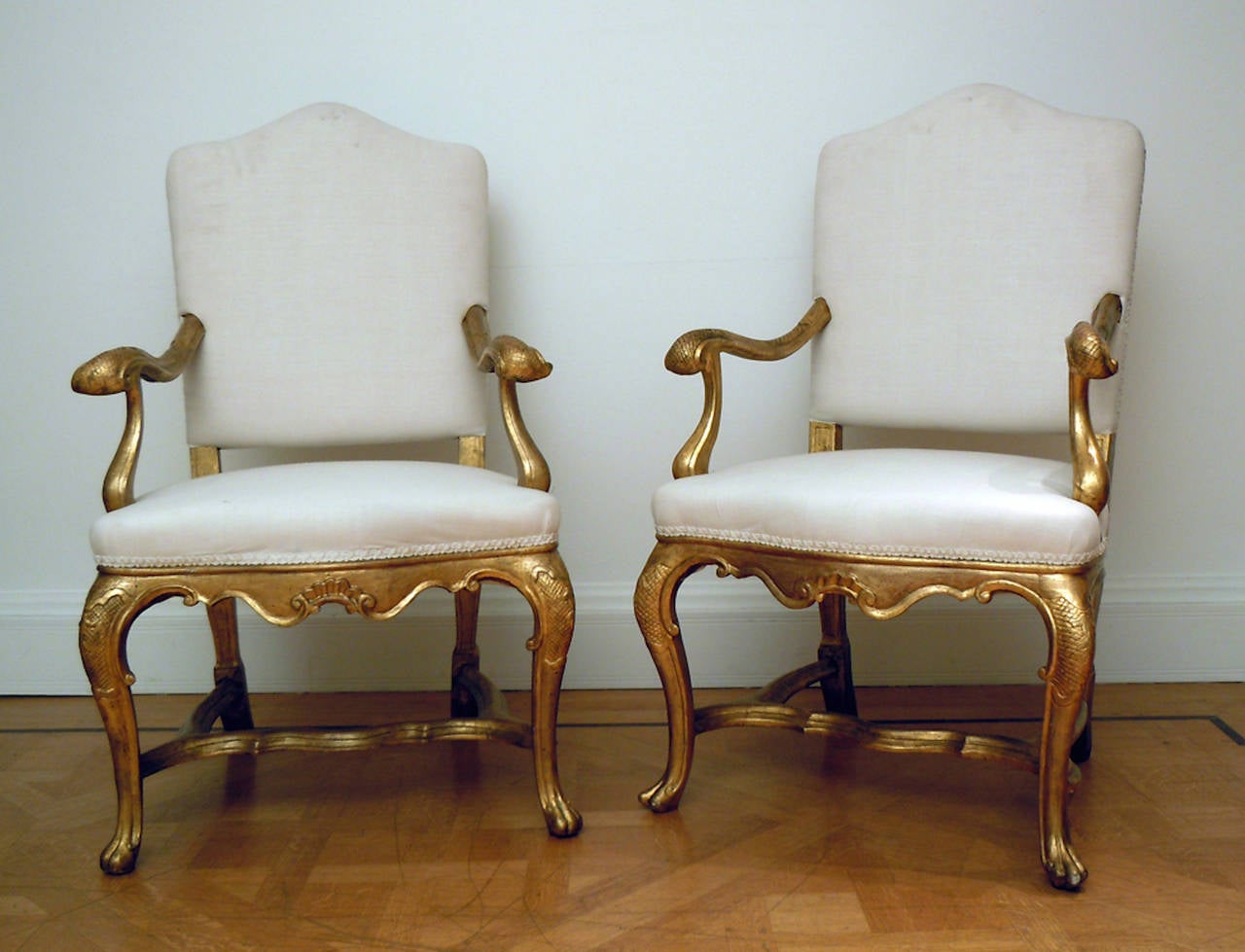 A fine pair of mid-18th century carved and giltwood Venetian armchairs with inverted bellflower carvings to the knees, shaped stretchers and curved arms, circa 1750. Venice.