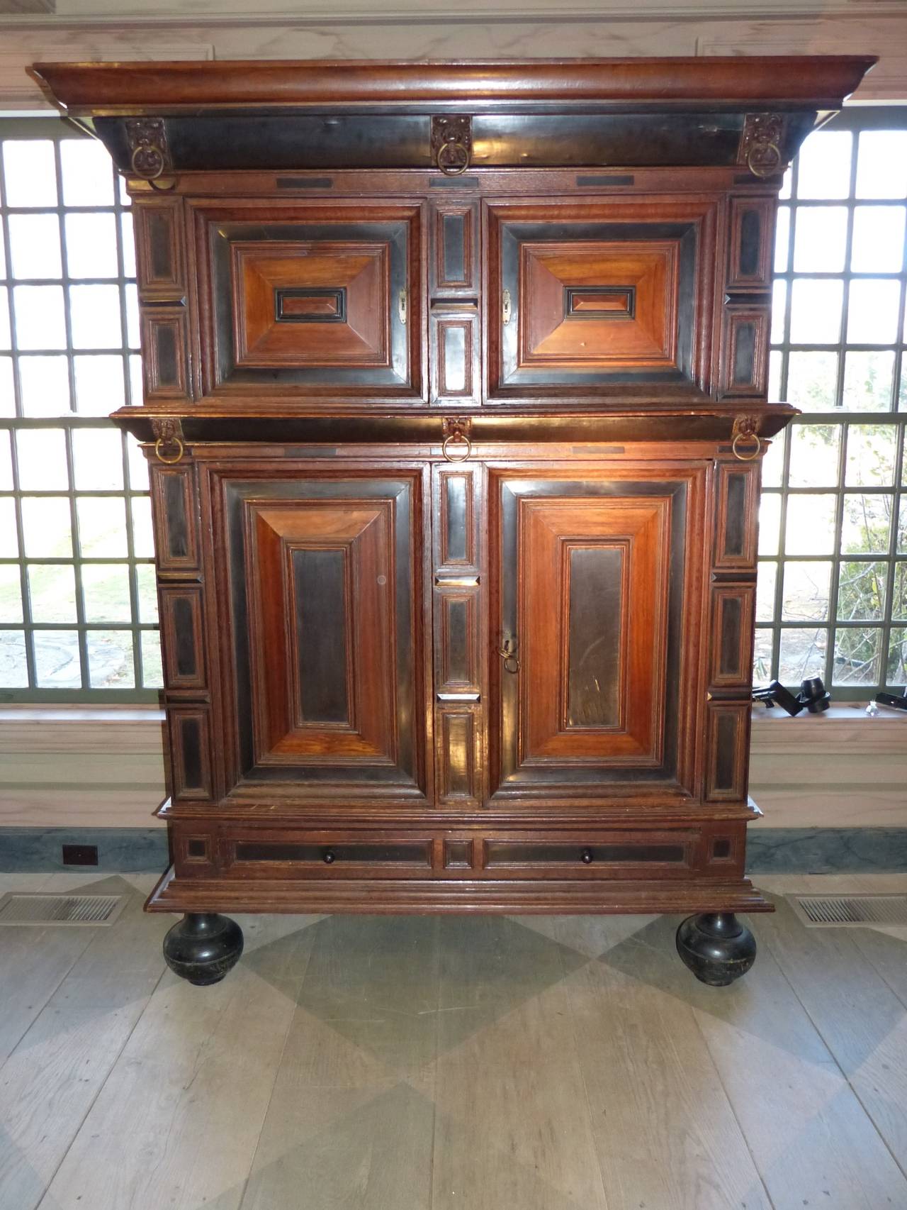 A large and imposing late 17th century Dutch oak kast or cupboard with ebony and rosewood highlights on bun feet, circa 1670.