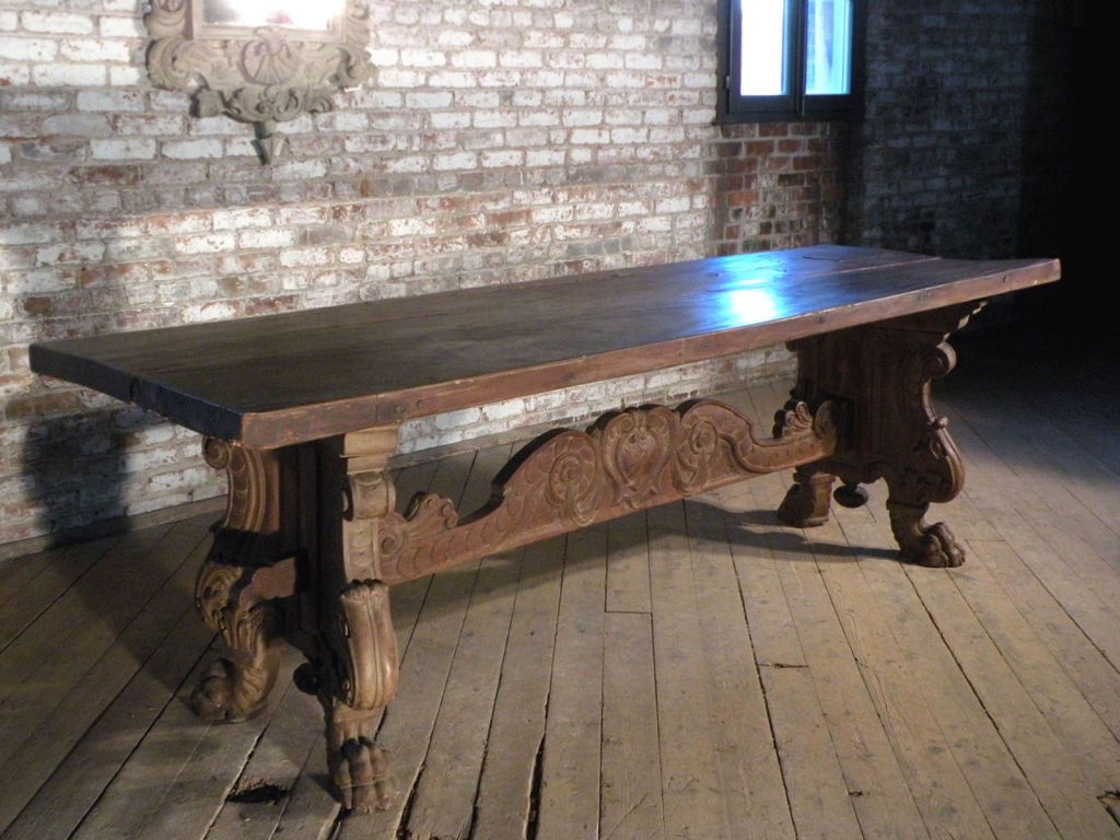 Table à tréteaux italienne avec un plateau à deux planches de deux pouces d'épaisseur et une base audacieusement sculptée.

