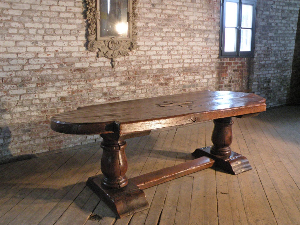 Imposing Refectory Table of Unusual Design with half-round ends and a Medieval Look. The almost 3.5 inch thick top adds to its bold appearance. The center of the top adorned with a deeply sculpted 