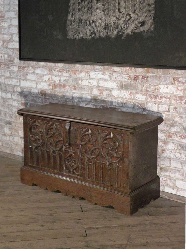 Lift top chest with typical carved Gothic tracery work adorning the front panel, of rather small proportion, beautiful color and extraordinary condition. Maintaining original hardware. Plinth most likely later, small interior box now missing.
