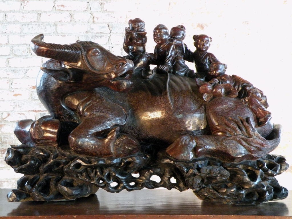 Sculpture chinoise de taille exceptionnelle représentant un buffle couché sur un socle en bois de racine sculpté simulé, avec cinq enfants sur son dos. Inhabituelle et rare pour sa taille et sa qualité, une pièce étonnante, belle et très décorative.
