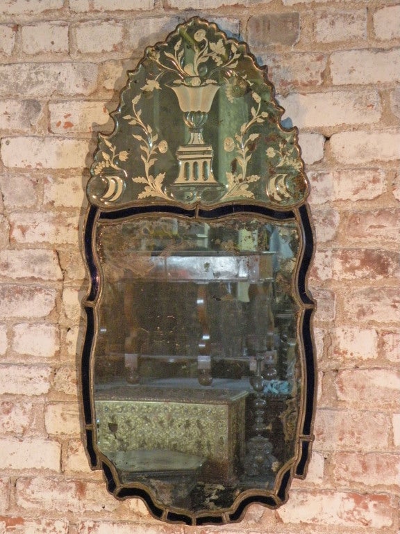 Charming shaped mirror with etched crest and intense blue edge, framed in lead.
