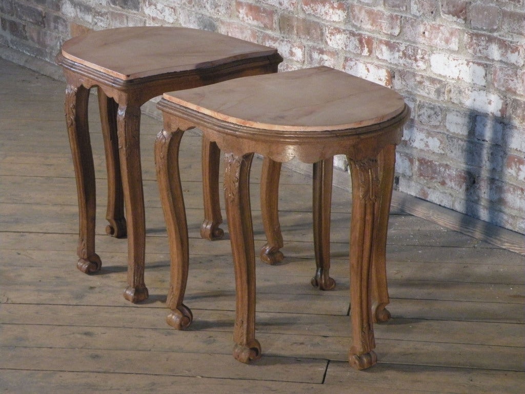 A pair of petit Regence side tables of very unusual design and beautiful understated detailing, with faux marbleized tops. They could also function as a pair of stools.
