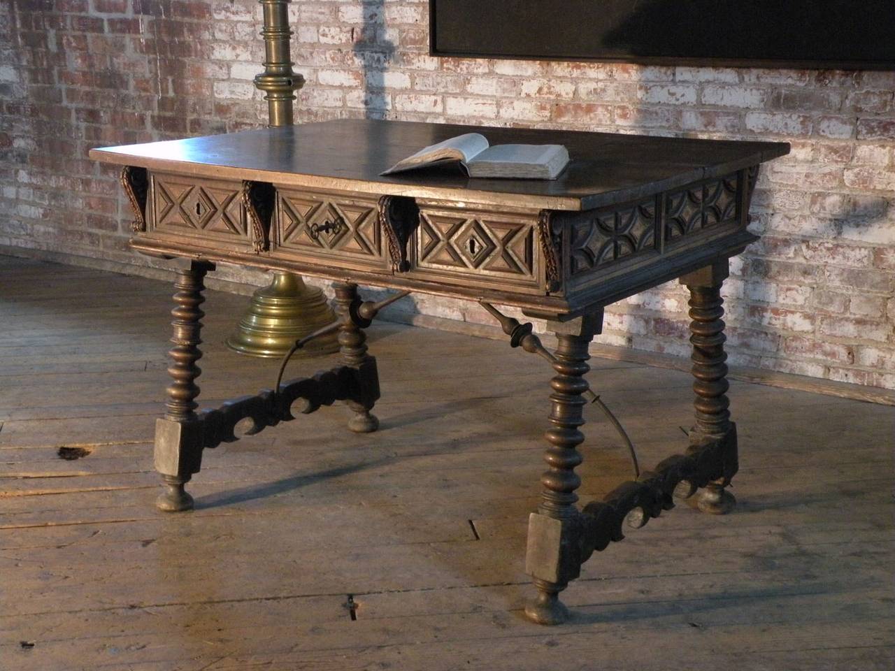 Superb model with a deeply paneled frieze, having geometric fruitwood inlay, containing three drawers. The strong disc-turned legs connected by shaped side stretchers and wrought iron middle stretchers. Excellent color and patina.

