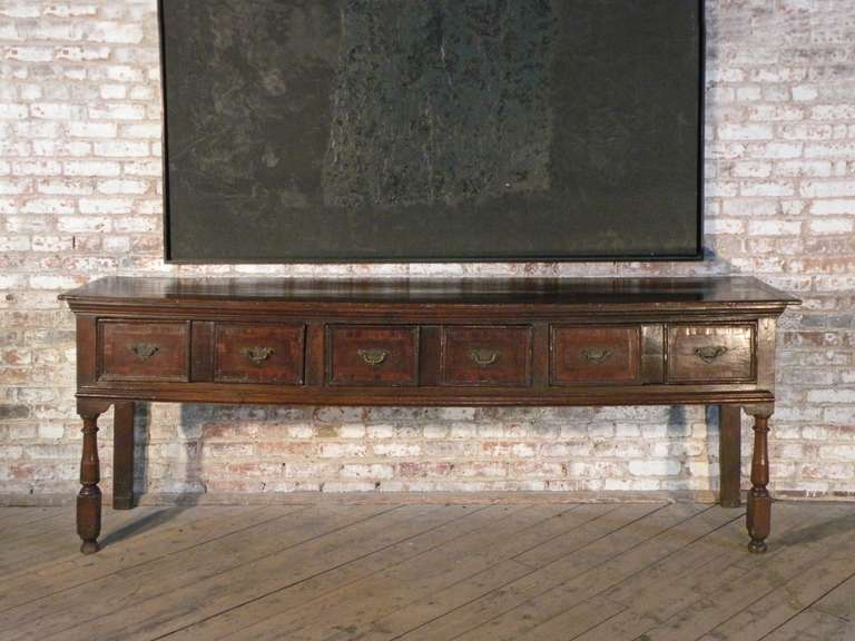 Long and narrow English dresser with three drawers. 
Simple elegant design with the subtle detail of veneered drawer fronts.
Drawer pulls re-mounted, two inches added to the legs (can be removed), minor old restoration.
