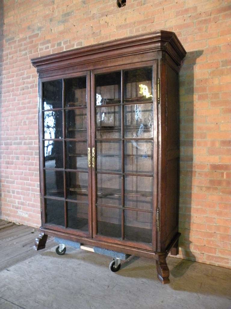 Double door vitrine / bookcase with glazed doors, retaining the original glass and four shaped display-shelves, (likely for the display of a china collection). The shelves could easily be replaced or covered with full, straight-edged shelves to give