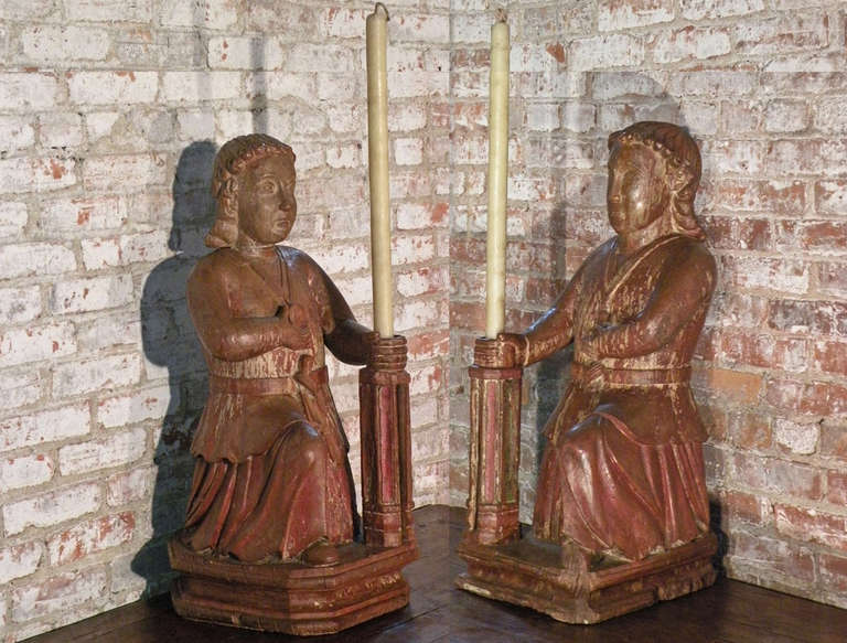 A rare pair of unusually large, candle-holding kneeling figures. Powerful, timeless examples of early colonial sculpture.
