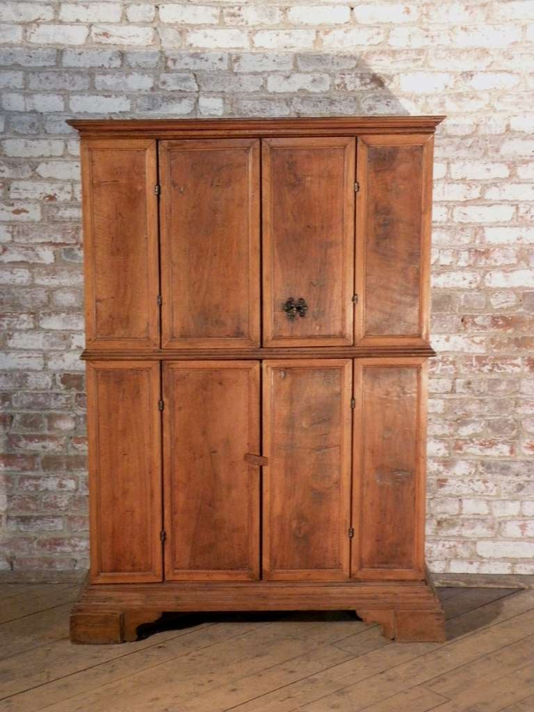 Tuscan cabinet or bookcase of unusual diminutive proportions and wonderful light honey color. The four doors opening to shelved interiors, on bracket feet.

