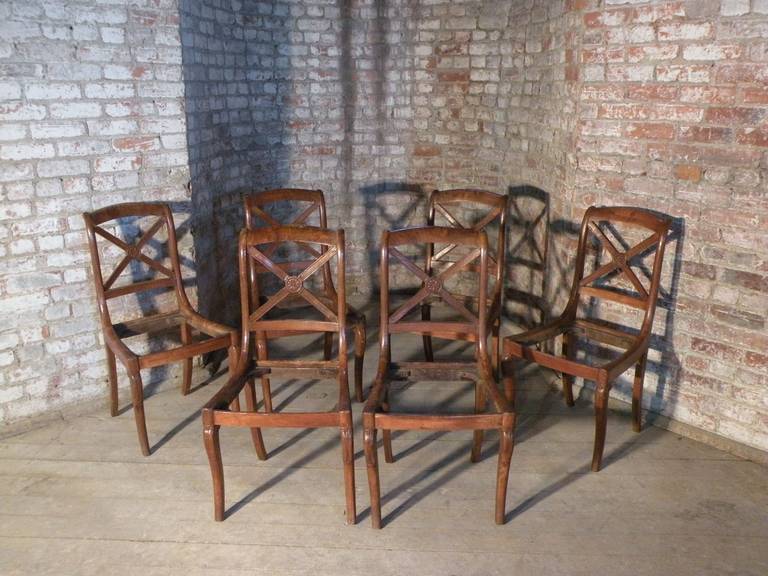 A set of six unusually small side chairs of typical form, the open backs featuring an X-centered by a carved flower, upholstered inset seats. 
Seats to be re-upholstered.

