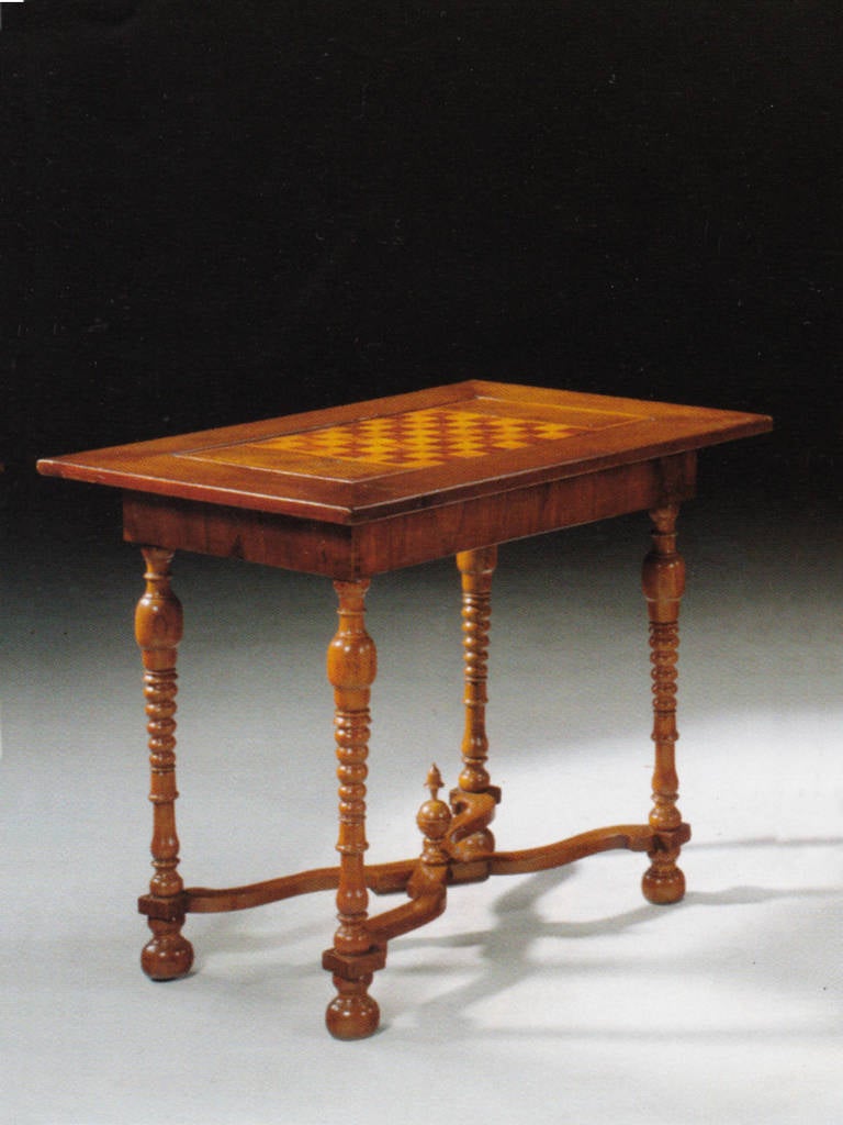 The inlaid top featuring a removable chessboard, revealing a sunken tric-trac board. The typically turned legs, ending in bun-feet, joined by a wavy X-stretcher and centered by a finial.
Our pieces are left in lived-in condition, pending our custom