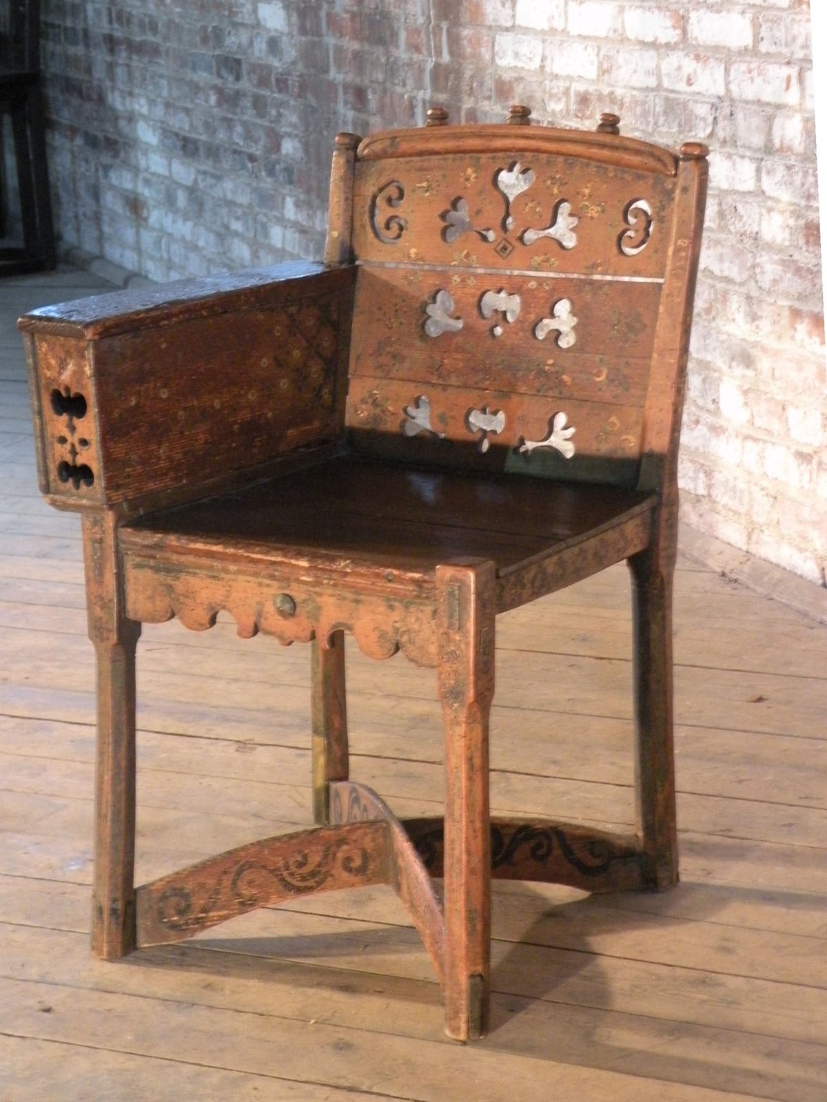 Adorable, unusual small chair, with one armrest, containing a small compartment. The original paint beautifully worn and faded (minor retouching and over paint on the bottom stretchers).
