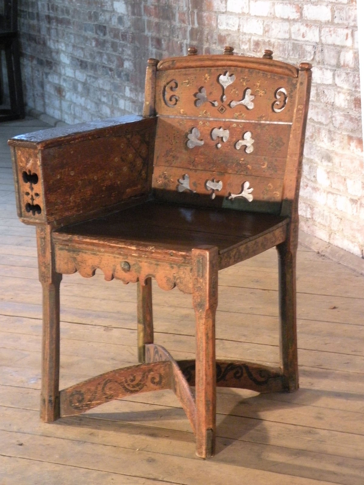 Adorable e inusual silla pequeña, con un reposabrazos, que contiene un pequeño compartimento. La pintura original está muy desgastada y descolorida (pequeños retoques y exceso de pintura en las camillas inferiores).
