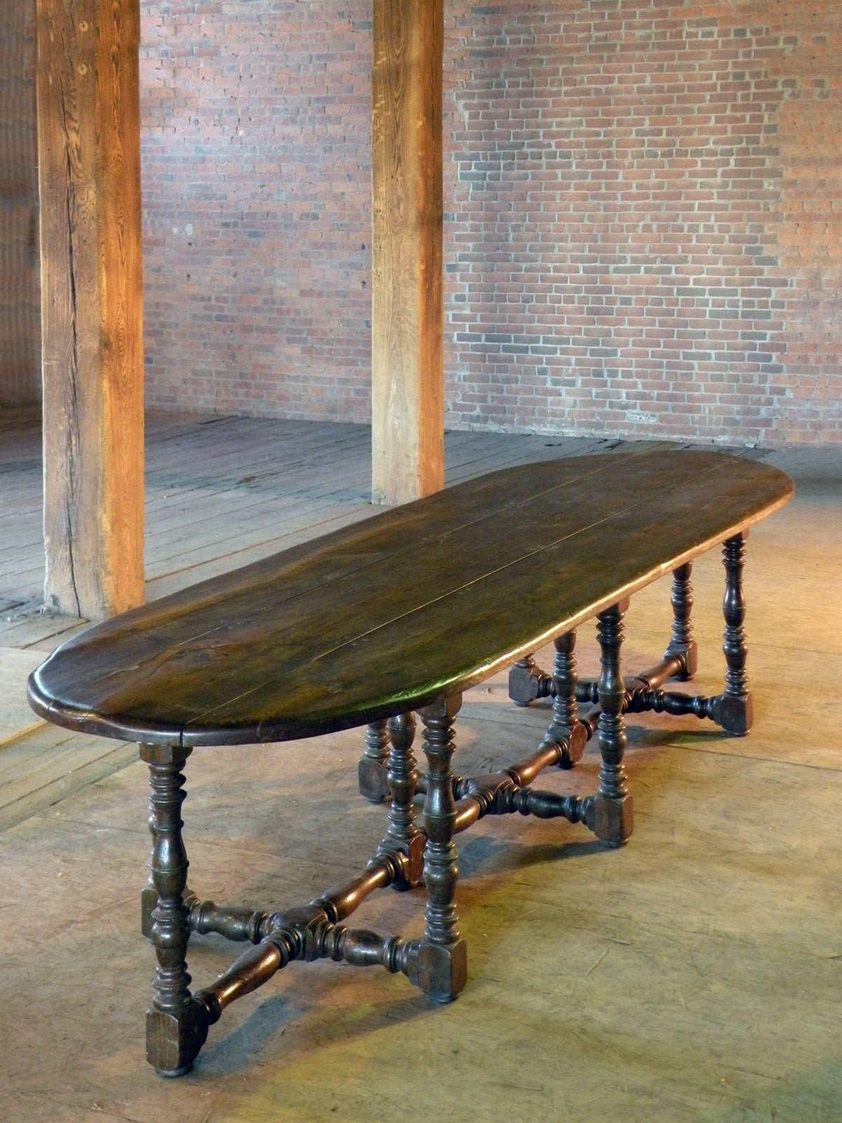 Exceptional, Large 17th Century Dining Table of unique and conceptual design. The over 11 feet long, massive three-board top with rounded ends supported by ten turned legs joined by conforming turned and beautifully worn down cross-stretchers.
Deep